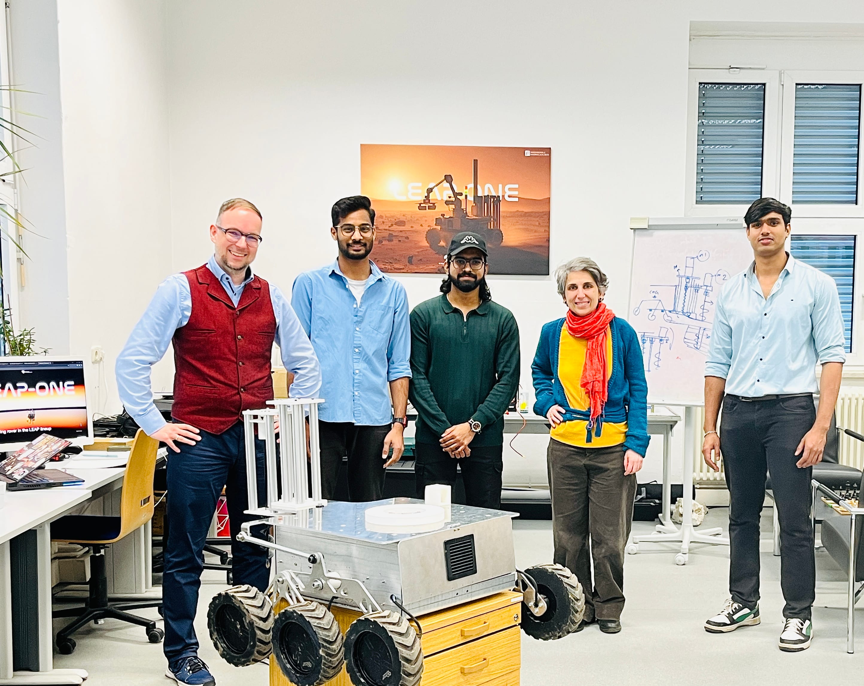 Team members and guests stand behind LEAP-One in the lab.
