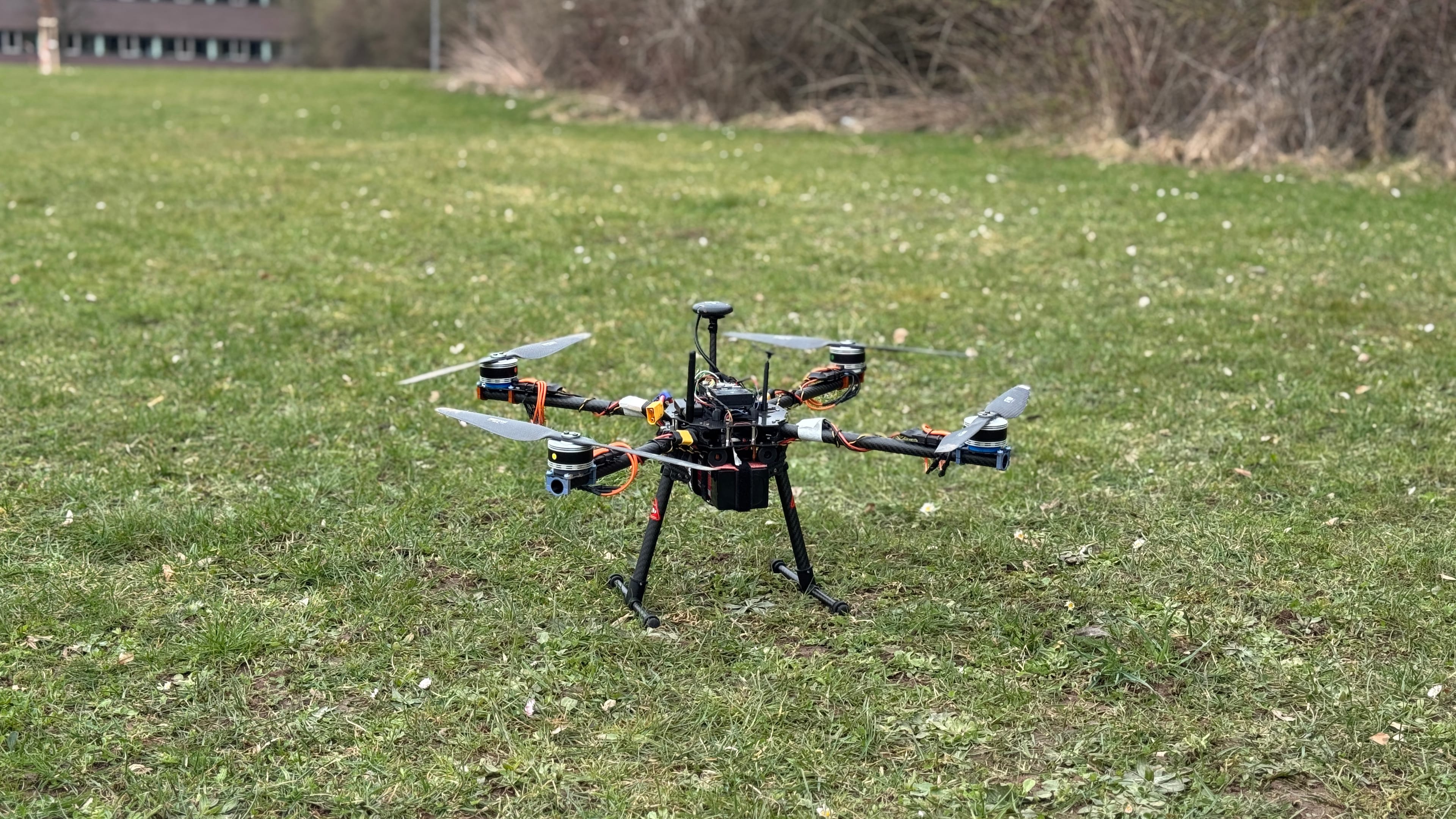 The AQUILA quadcopter set down on the grass during field operations.