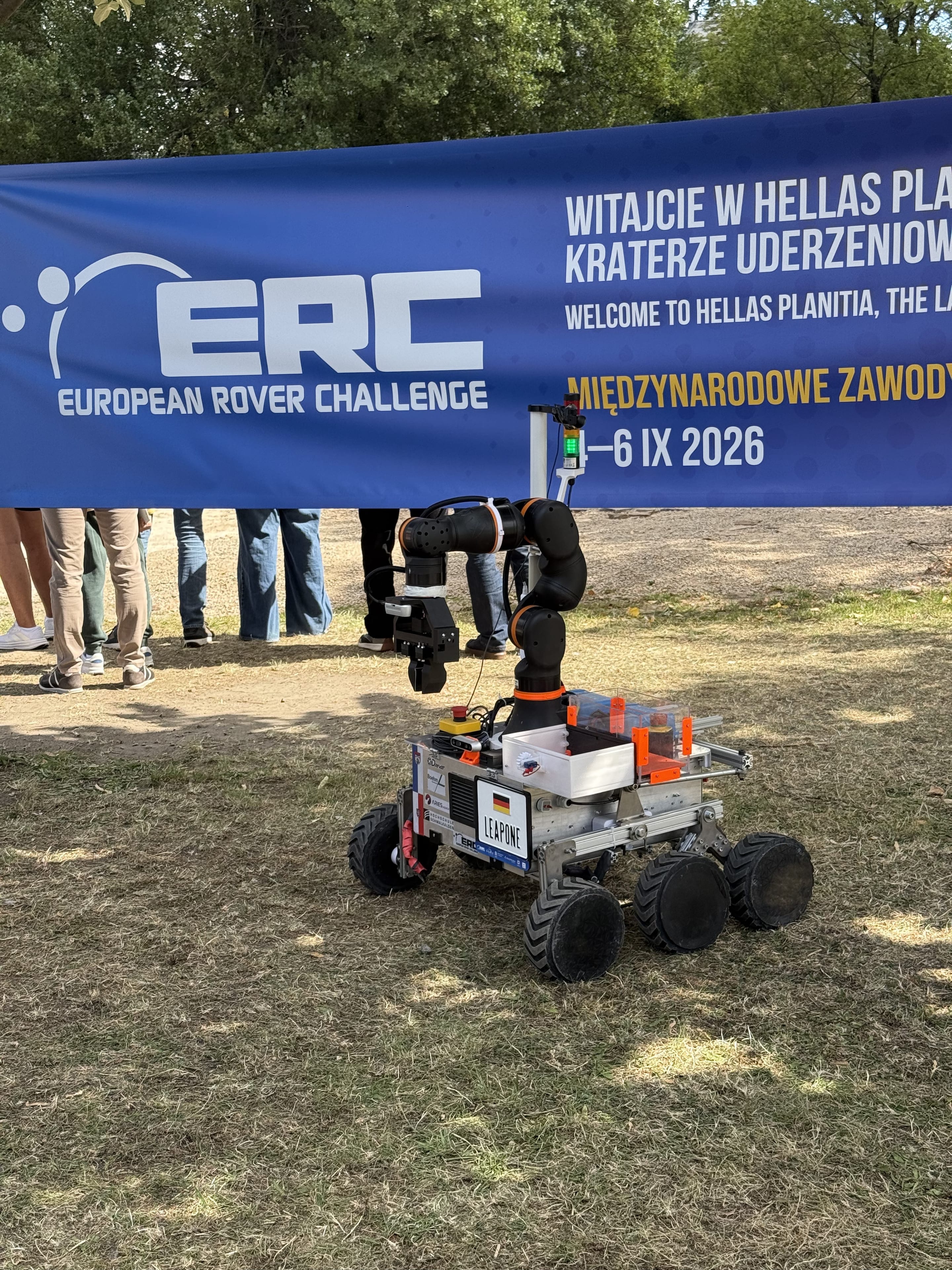 LEAP-One raises its arm on the grass beneath the blue ERC welcome banner.