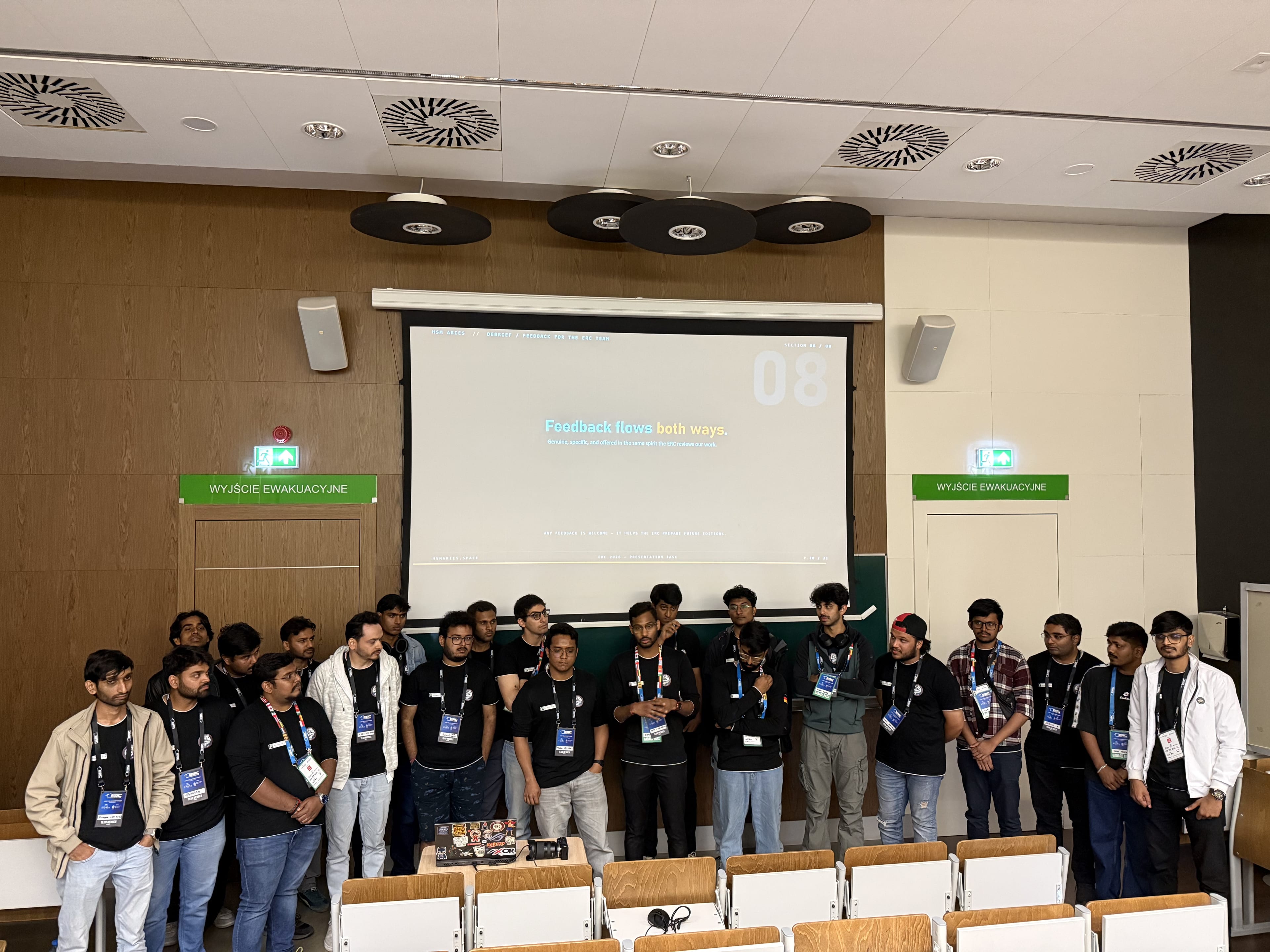 The team lines up under the projector screen after the presentation.