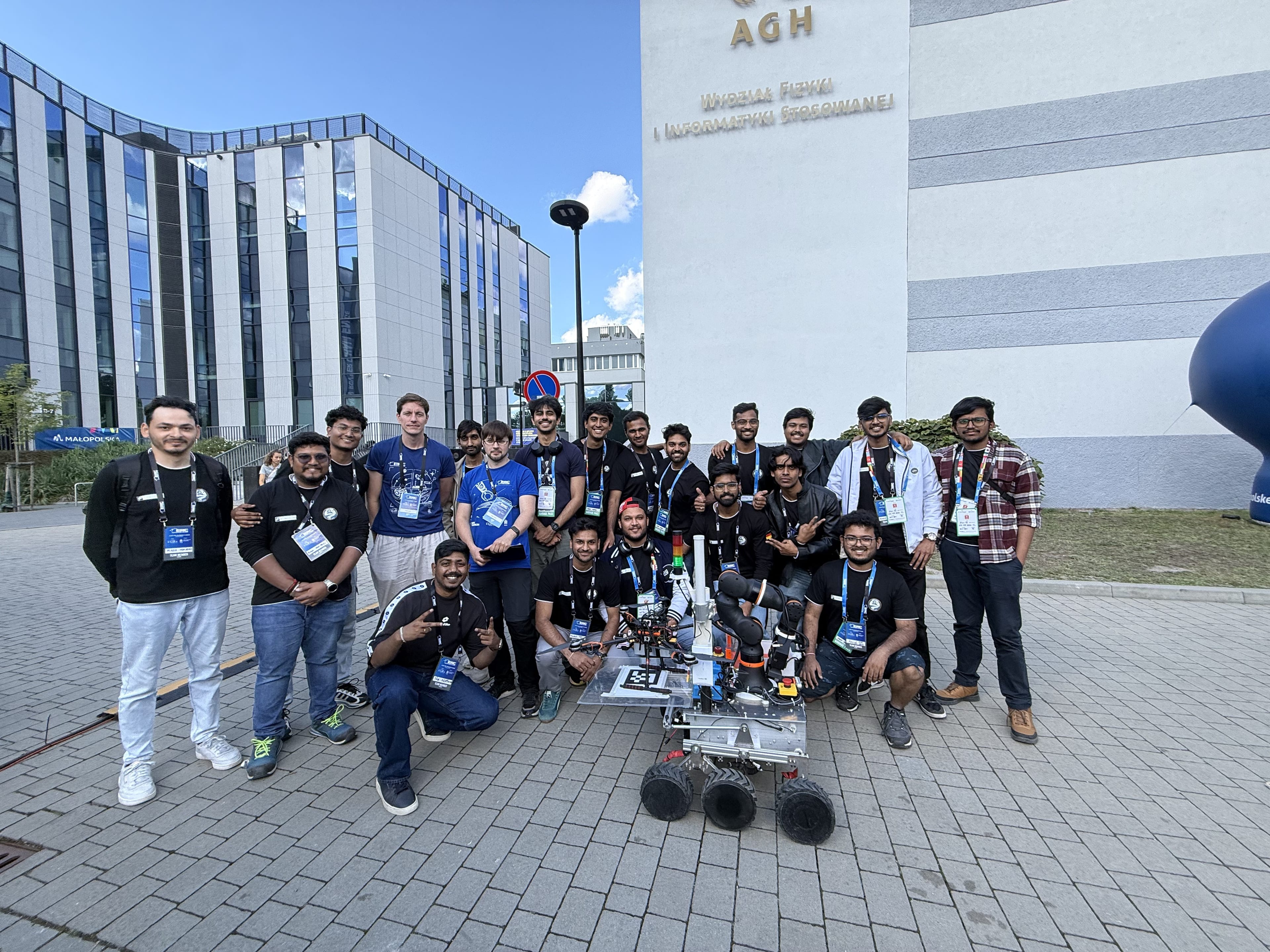 The team gathers around LEAP-One under the AGH faculty lettering at the host university.