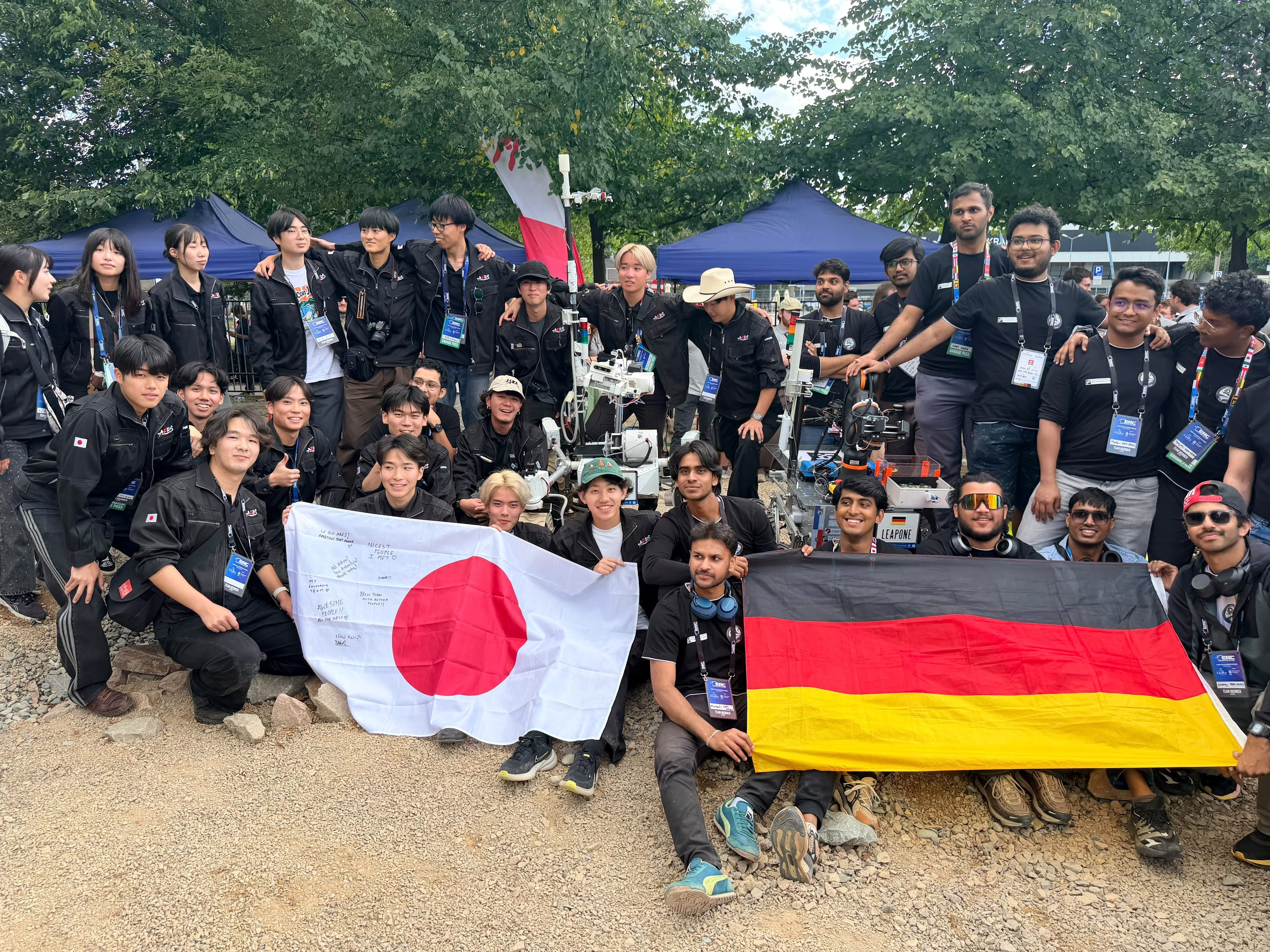The team poses with the Japanese team, both flags side by side and LEAP-One behind them.