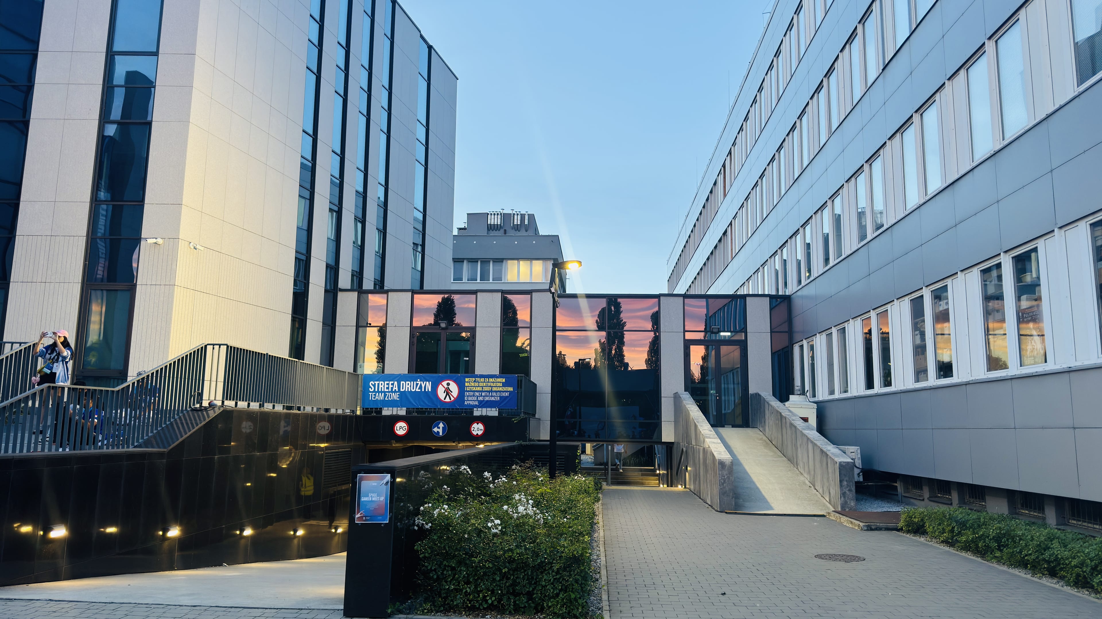 The sunset is reflected in the glass facade above the ERC team-zone entrance at AGH.