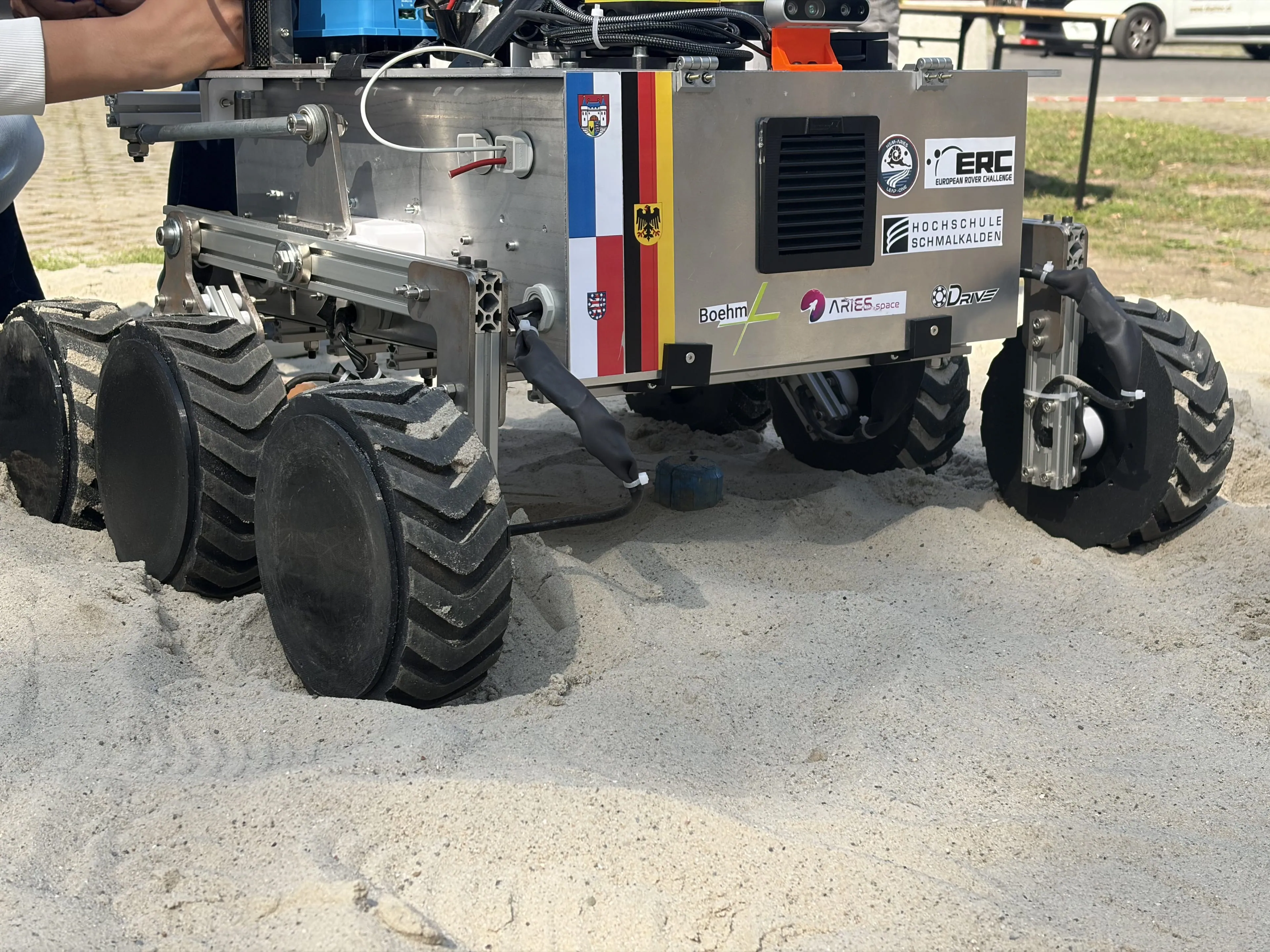 LEAP-One's wheels dig into the sand during the test, with the sponsor and flag decals on its flank.